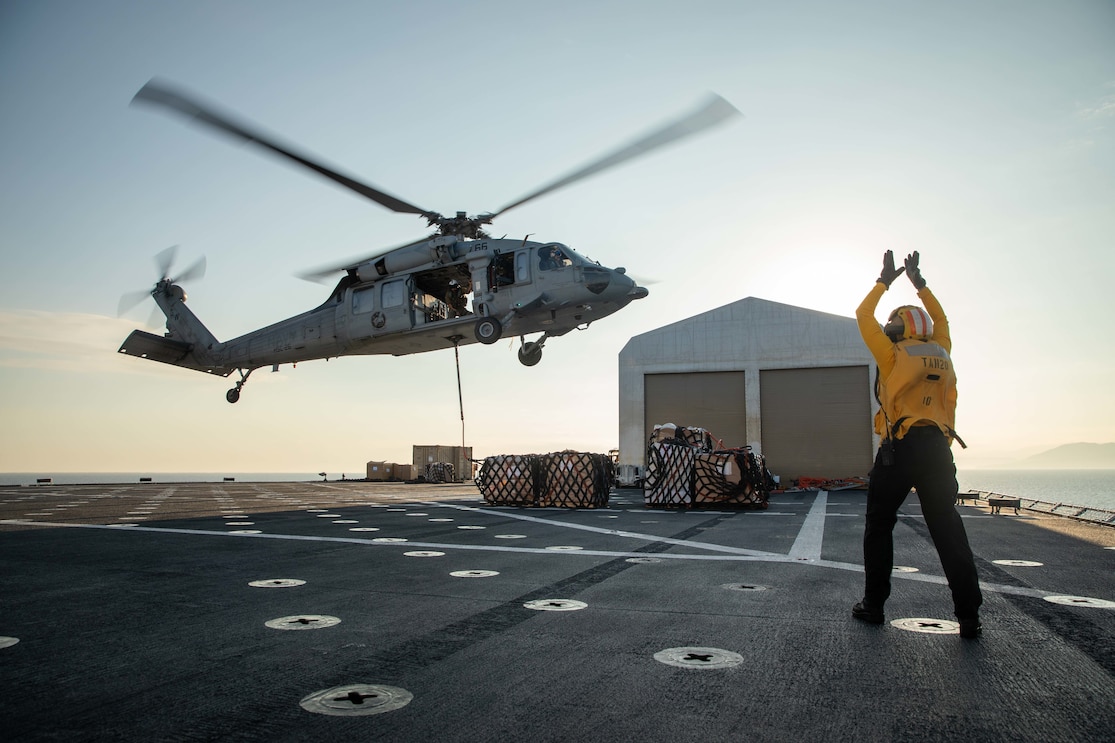 JEREMIE, Haiti (Dec. 17, 2022) Aviation Boatswain’s Mate (Aircraft Handling) 2nd Class Kelsey Turner, assigned to the hospital ship USNS Comfort (T-AH 20), directs the pilot of an MH60-S Seahawk, attached to the “Chargers” of Helicopter Sea Combat Squadron (HSC) 26, to deliver supplies to the medical site in Jeremie, Haiti, Dec. 17, 2022. Comfort is deployed to U.S. 4th Fleet in support of Continuing Promise 2022, a humanitarian assistance and goodwill mission conducting direct medical care, expeditionary veterinary care, and subject matter expert exchanges with five partner nations in the Caribbean, Central and South America. (U.S Army photo by Sgt. Ruben Rodriguez Santiago)