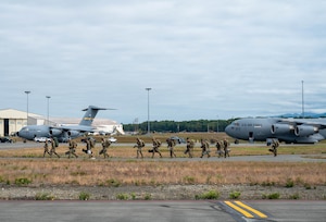 Airmen walking on a flightline with C-17 Globemaster III's in the background