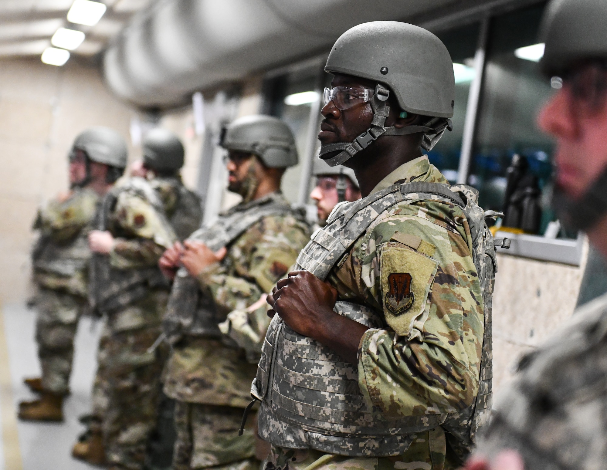 Airmen stand ready to qualify on the M-4 weapons platform at Offutt Air Force Base, June 4, 2025. Trainees must be able to shoot from the following positions to qualify: prone supported, prone unsupported, kneeling supported, and over barricade. (U.S. Air Force photo by Chad Watkins)