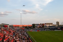 Fans cheer as a 433rd Airlift Wing C-5M Super Galaxy soars over Toyota Field during the first flyover by a military aircraft at a San Antonio FC soccer match in San Antonio, Texas, July 12, 2025.