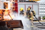 U.S. Air Force firefighters assigned to the 169th Civil Engineer Squadron’s fire department and the 374th Civil Engineer Squadron’s fire department conduct car burn procedures during a deployment for a training course at Yokota Air Base, Japan, July 5, 2025.