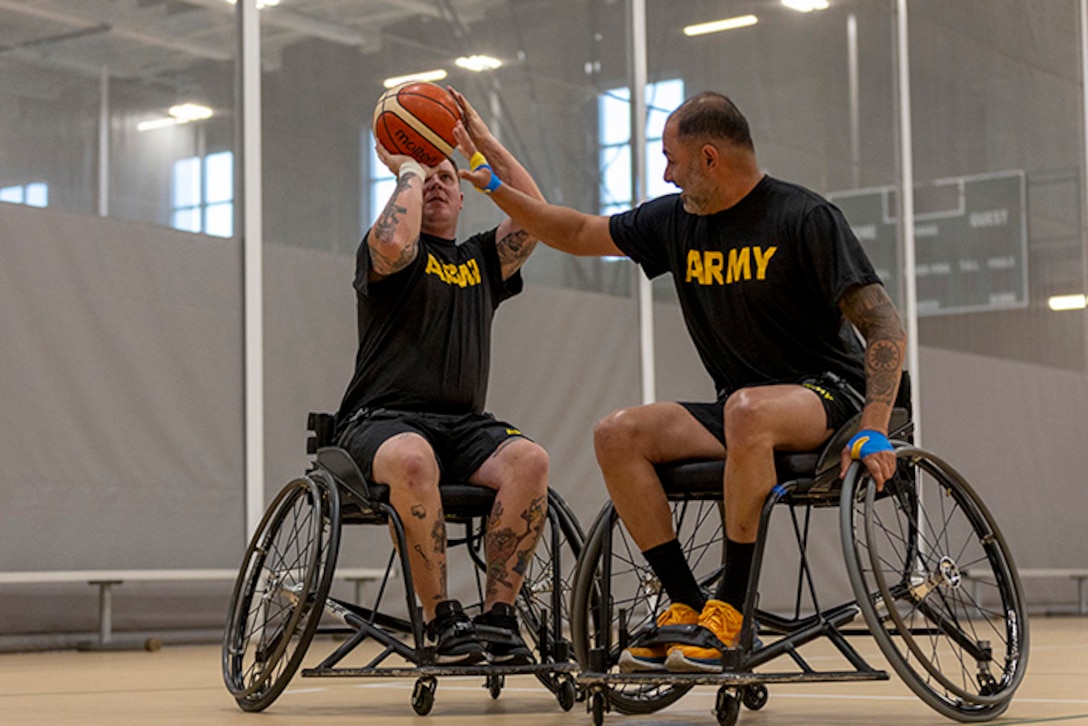 U.S. Army Staff Sgt. Tyler Pollard, left, shoots the ball while Capt. Carlos Rivera attempts to block while conducting drills at wheelchair basketball practice during the 2025 Department of Defense Warrior Games practice sessions at Fort Carson, Colorado, July 14, 2025.