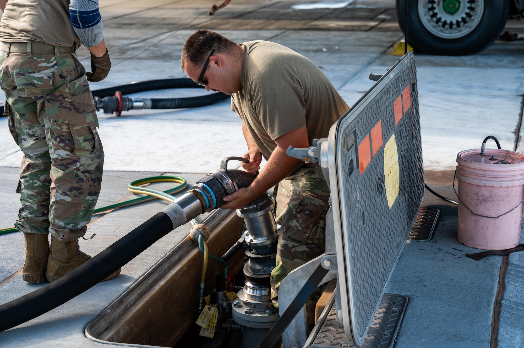 U.S. Air Force Staff Sgt. Jacob Wells, 7th Logistics Readiness Squadron fuels distribution supervisor, connects a R-12 hydrant refueling truck to a hydrant outlet during a hot pit refuel at Dyess Air Force Base, Texas, July 8, 2025. Hot pit refueling is a rapid ground refueling method in which aircraft are serviced immediately after landing with engines still running, allowing aircrews to relaunch without shutting down. (U.S. Air Force photo by Airman 1st Class Adrien Tran)