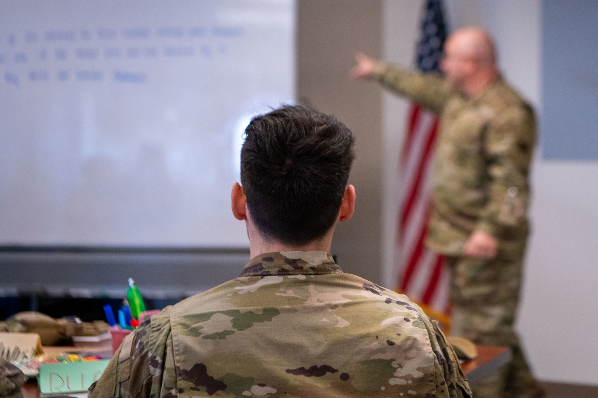An Airman in uniform sits in a classroom for a course.