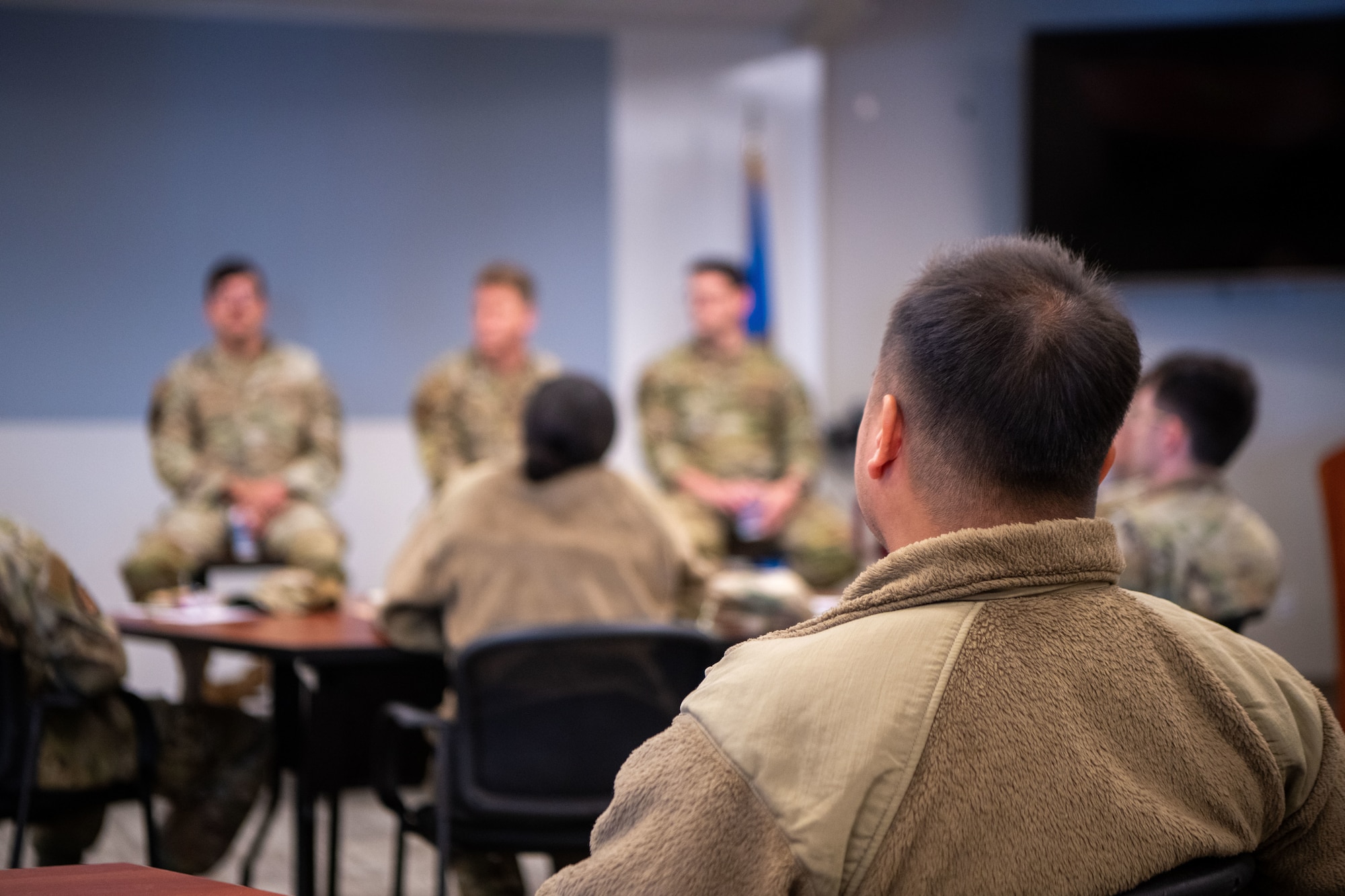 An Airman in uniform sits in a classroom for a course.