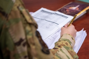 An Airman in uniform sits in a classroom for a course.