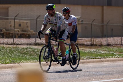 Team Army coach Greg Miller, left, and U.S. Army Sgt. 1st Class Henry Escobedo complete the final lap during cycling practice on a tandem bike during the 2025 Department of Defense Warrior Games at Fort Carson, Colorado, July 13, 2025.