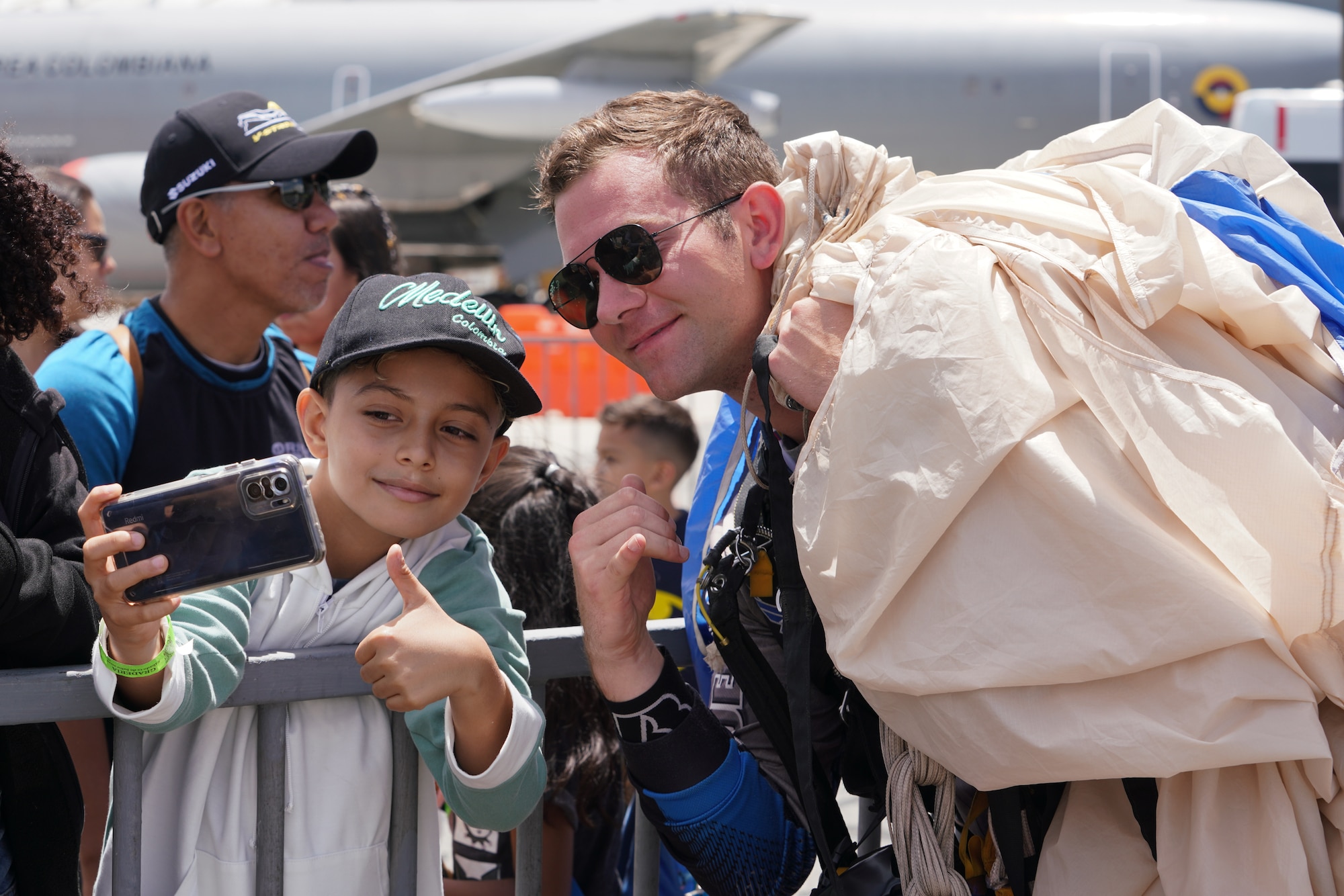A U.S. Air Force Academy Wings of Blue member poses for a photo with a spectator during F-AIR 2025, the Colombia Feria Aeronáutica Internacional, at the José María Córdova International Airport in Rionegro, Antioquia, Colombia, July 12, 2025. The United States remains an enduring and committed partner to Colombia, maintaining robust engagement across Latin America and the Caribbean. (U.S. Air Force photo by Staff Sgt. Ariel O’Shea)