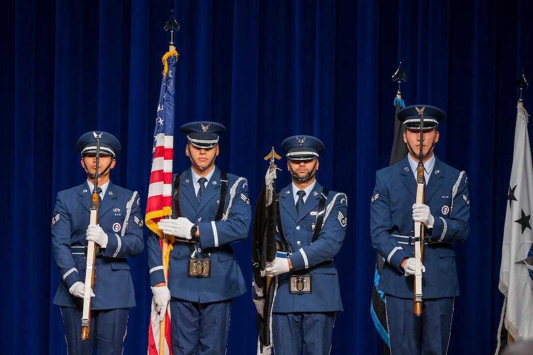 Patrick Space Force’s honor guard present the colors during the national anthem at Space Training and Readiness Command’s change of command ceremony at Patrick Space Force Base. Men standing in uniform with flags.