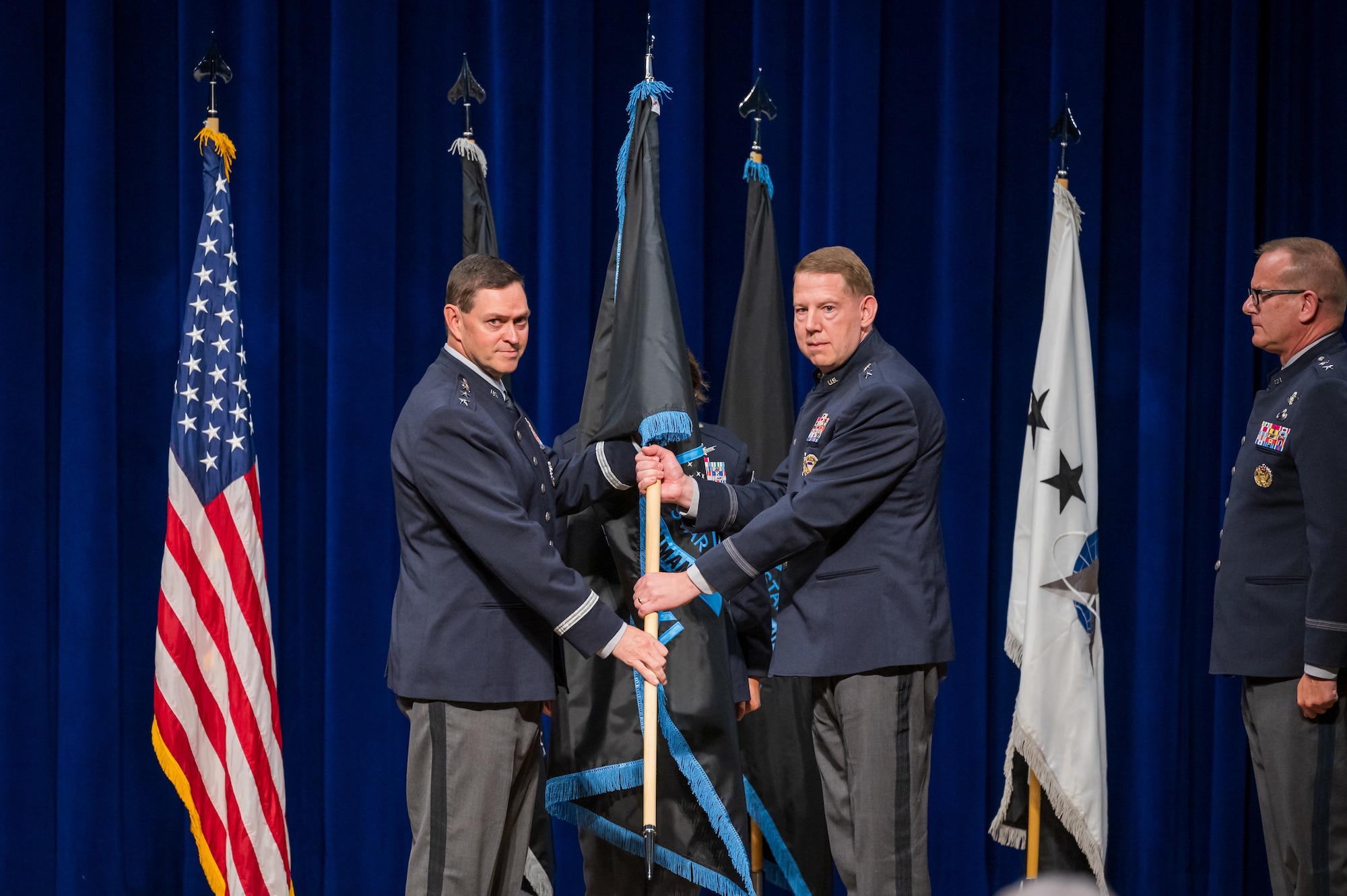 Gen. Chance Saltzman, Chief of Space Operations, passes the Space Training and Readiness Command guidon to Maj. Gen. James E. Smith during a change of command ceremony at Patrick Space Force Base, Fla., July 18, 2025. Guardians in uniform with guidon and flags.