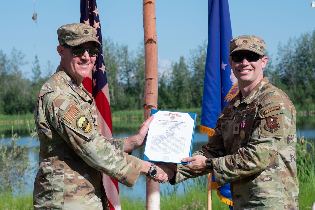 U.S. Air Force Maj. Kaleb Marsh, right, Detachment 1, 66th Training Squadron outgoing commander, receives the Meritorious Service Medal from Lt. Col. Nathan Lowry, 66th TRS commander, during a change of command ceremony at Eielson Air Force Base, Alaska, July 18, 2025.