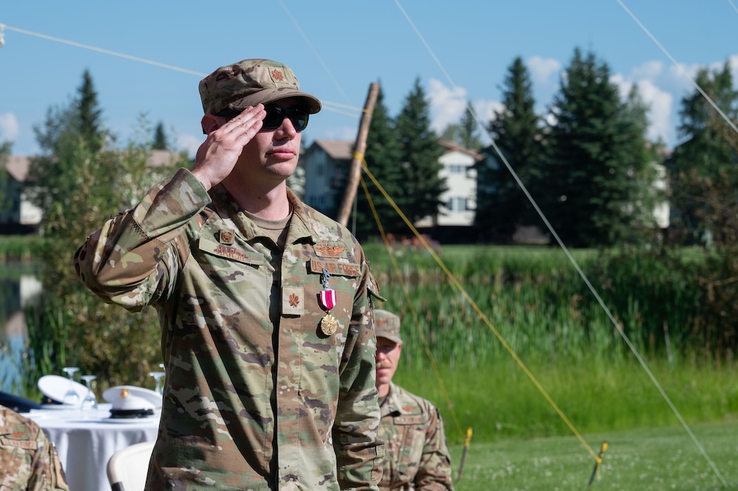 U.S. Air Force Maj. Kaleb Marsh, right, Detachment 1, 66th Training Squadron outgoing commander, renders a final salute to SrA Alexander Denny, Detachment 1, 66th TRS Survival, Evasion, Reconnaissance, and Escape specialist, during a change of command ceremony at Eielson Air Force Base, Alaska, July 18, 2025.