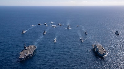 TIMOR SEA (July 18, 2025) — U.S. Navy aircraft, attached to Carrier Air Wing (CVW) 5, fly over U.S. Navy George Washington Carrier Strike Group, as it participates in dual carrier operations alongside Royal Navy HMS Prince of Wales Carrier Strike...