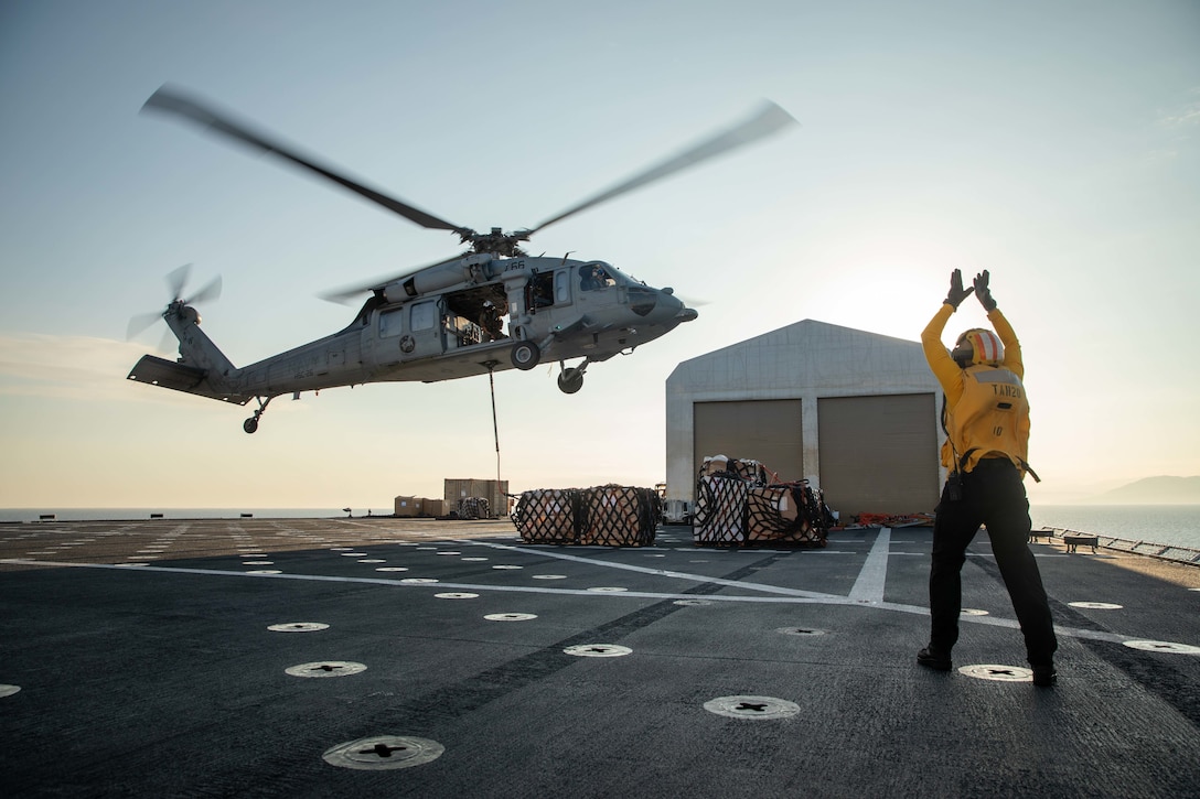 JEREMIE, Haiti (Dec. 17, 2022) Aviation Boatswain’s Mate (Aircraft Handling) 2nd Class Kelsey Turner, assigned to the hospital ship USNS Comfort (T-AH 20), directs the pilot of an MH60-S Seahawk, attached to the “Chargers” of Helicopter Sea Combat Squadron (HSC) 26, to deliver supplies to the medical site in Jeremie, Haiti, Dec. 17, 2022. Comfort is deployed to U.S. 4th Fleet in support of Continuing Promise 2022, a humanitarian assistance and goodwill mission conducting direct medical care, expeditionary veterinary care, and subject matter expert exchanges with five partner nations in the Caribbean, Central and South America. (U.S Army photo by Sgt. Ruben Rodriguez Santiago)