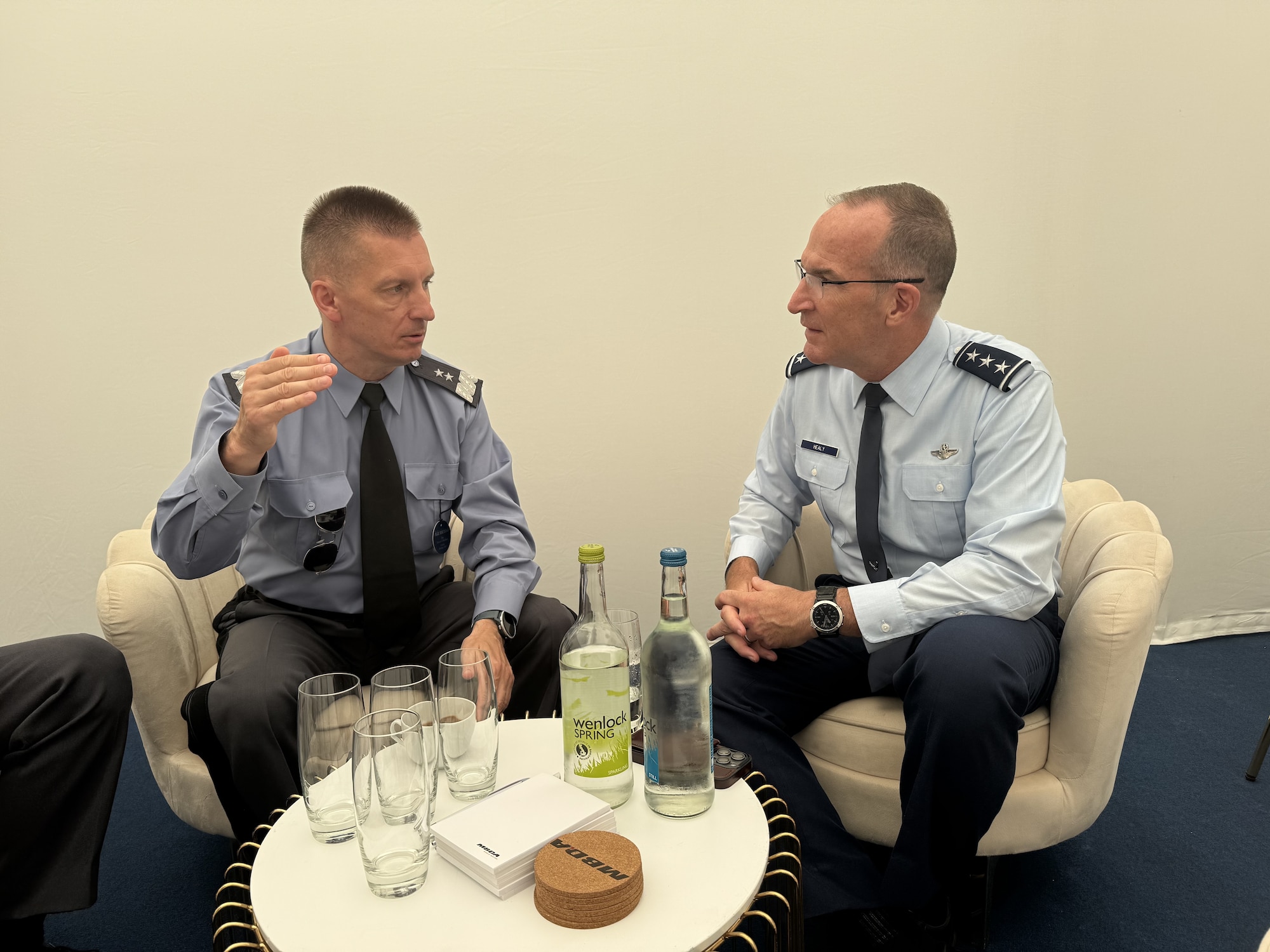 Two men sit talking