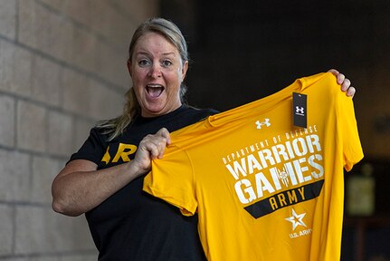 U.S. Army Maj. Mandy Feindt shows off her Team Army t-shirt at the uniform issue during the 2025 Department of Defense Warrior Games at Colorado Springs, Colorado, July 15, 2025.