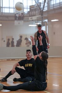 U.S. Army Sgt. 1st Class Alberto Alvarez, left, watches as Sgt. Bianca Hayden sets the ball at sitting volleyball practice during the 2025 Department of Defense Warrior Games training camp at Fort Carson, Colorado, July 15, 2025.