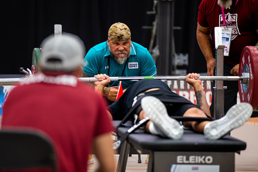 U.S. Army Staff Sgt. Nathaniel Mateo  pushes hard to finish his first rep in the powerlifting event during the 2025 Department of Defense Warrior Games at Reid Arena, Colorado Springs, Colorado, July 18, 2025.