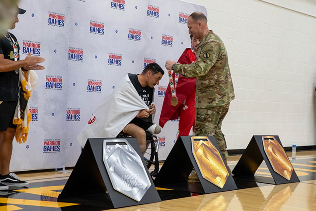 U.S. Army Retired Sgt. Jason Smith is awarded gold medal in powerlifting by Sgt. Maj. Christopher Carey, the Deputy Chief of Staff Sergeant Major, U.S. Army Training and Doctrine Command, during the 2025 Department of Defense Warrior Games at Reid Arena, Colorado Springs, Colorado, July 18, 2025.