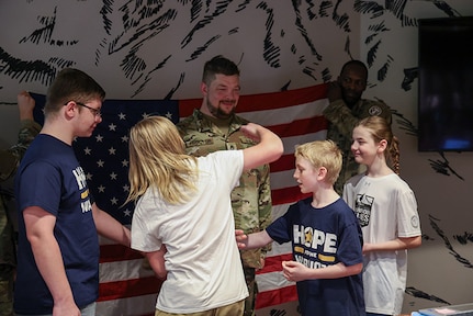 Family members of Sgt. 1st Class Adam Proctor celebrate his new rank at his promotion ceremony during the 2025 Department of Defense Warrior Games at Colorado Springs, Colorado, July 18, 2025.
