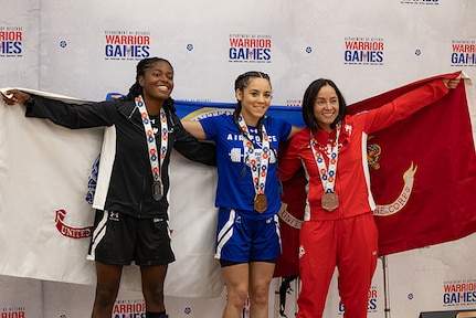 U.S. Army 1st Lt. Jani Merritt, left, silver medalist,  U.S. Air Force Tech. Sgt. Nicole Stickel, center, gold medalist, and U.S. Marine Corps Gunnery Sgt. Tracey Rodriguez, right, bronze medalist, pose for a photo during the powerlifting medal ceremony at the 2025 Department of Defense Warrior Games at Colorado Springs,