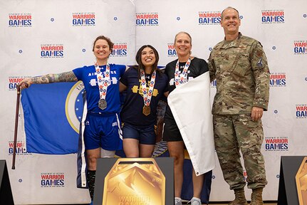 U.S. Air Force Master Sgt. Lyndie Stark, left, silver medalist, U.S. Navy Petty Officer 3rd Class Michaela Infante, center, gold medalist, and U.S. Army Maj. Amy Sparks, center-right, bronze medalist, pose for a photo with U.S. Air Force Maj. Gen. Jefferson O'Donnell, commander, Air Force Personnel Center, at the powerlifting competition during the 2025 Department of Defense Warrior Games at Colorado Springs, Colorado, July 18, 2025.