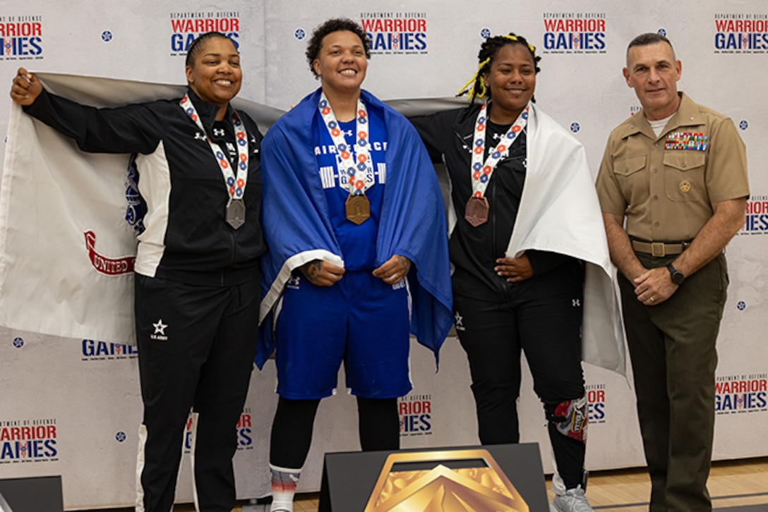 U.S. Army Capt. Channda Mitchell, left, silver medalist, U.S. Air Force Staff Sgt. Tinalouise Dunbar, center, gold medalist, and U.S. Army Sgt. 1st Class Valerie Watkins, center-right, bronze medalist, pose for a photo with U.S. Marine Corps Brig. Gen.