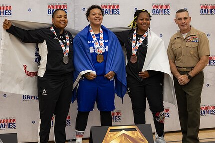 U.S. Army Capt. Channda Mitchell, left, silver medalist, U.S. Air Force Staff Sgt. Tinalouise Dunbar, center, gold medalist, and U.S. Army Sgt. 1st Class Valerie Watkins, center-right, bronze medalist, pose for a photo with U.S. Marine Corps Brig. Gen.