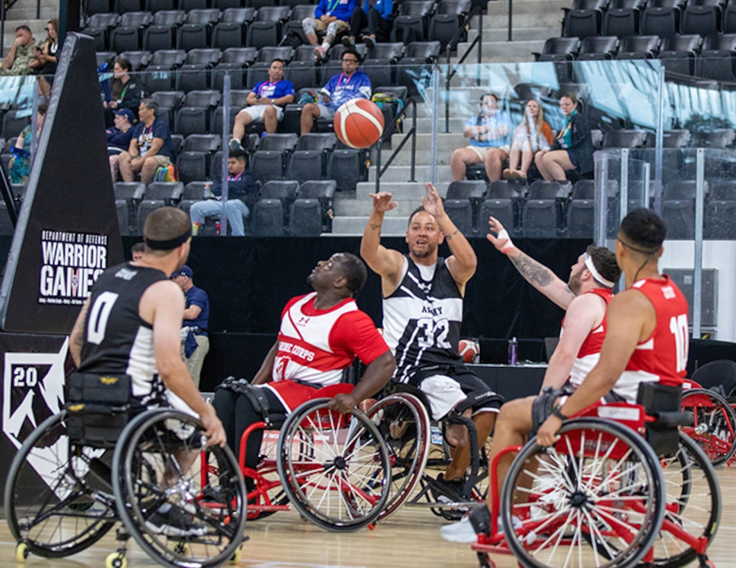 U.S. Army Spc. Anthony Farve passes the ball over defenders during a wheelchair basketball game at the 2025 Department of Defense Warrior Games at Ed Robson Arena in Colorado Springs, Colorado, July 19, 2025.