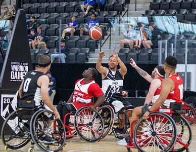 U.S. Army Spc. Anthony Farve passes the ball over defenders during a wheelchair basketball game at the 2025 Department of Defense Warrior Games at Ed Robson Arena in Colorado Springs, Colorado, July 19, 2025.