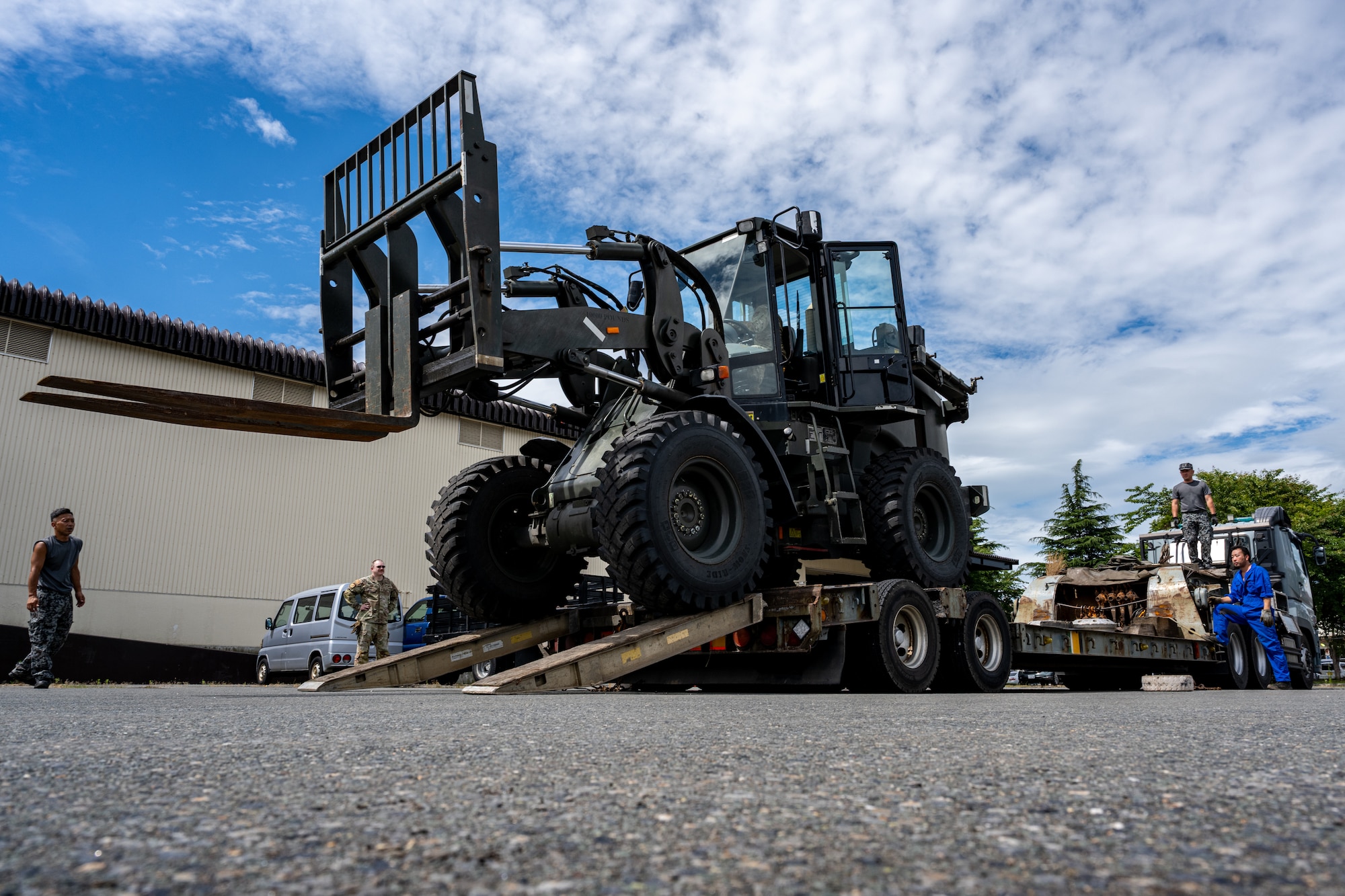 U.S. Air Force Airmen assigned to the 35th Logistics Readiness Squadron and Japan Air Self-Defense Force Airmen assigned to the 3rd Air Wing guide and load a forklift on a truck during exercise Resolute Force Pacific (REFORPAC) 2025.