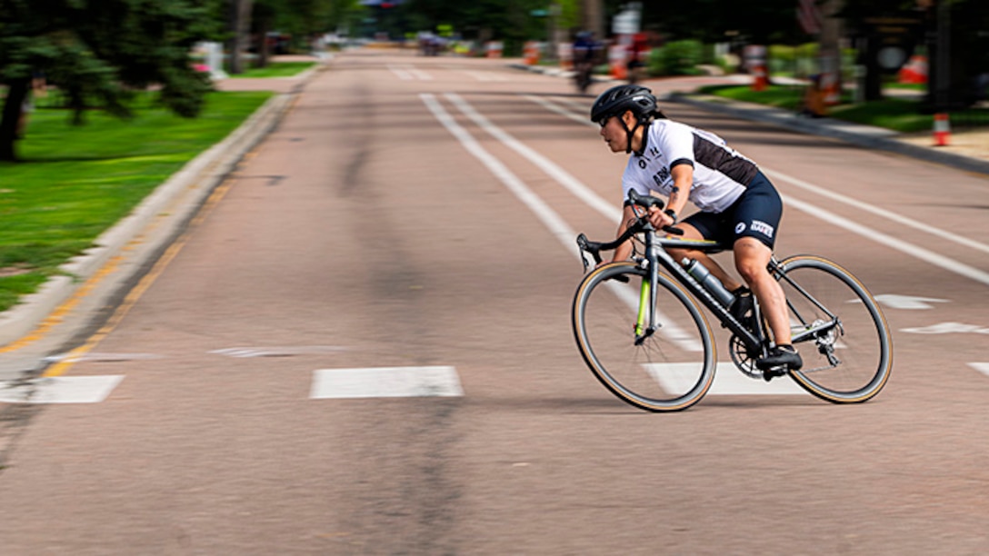 Retired U.S. Army Capt. Kyra Maggio takes a corner in the women's upright bicycle road race at the cycling event during the 2025 Department of Defense Warrior Games at Colorado Springs, Colorado, July 19, 2025.