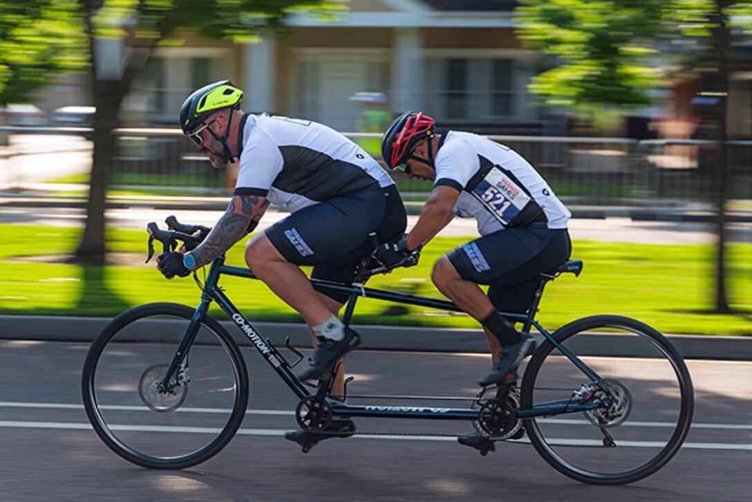 U.S. Army Retired Sgt. 1st Class Henry Escobedo, right, competes in time trials with his pilot, Team Army coach Greg Quarles at the cycling event during the 2025 Department of Defense Warrior Games at Colorado Springs, Colorado, July 19, 2025.