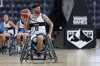 U.S. Army Staff Sgt. John Michael Britton looks for an open teammate to pass to in a wheelchair basketball game during the 2025 Department of Defense Warrior Games at Colorado Springs, Colorado, July 19, 2025.