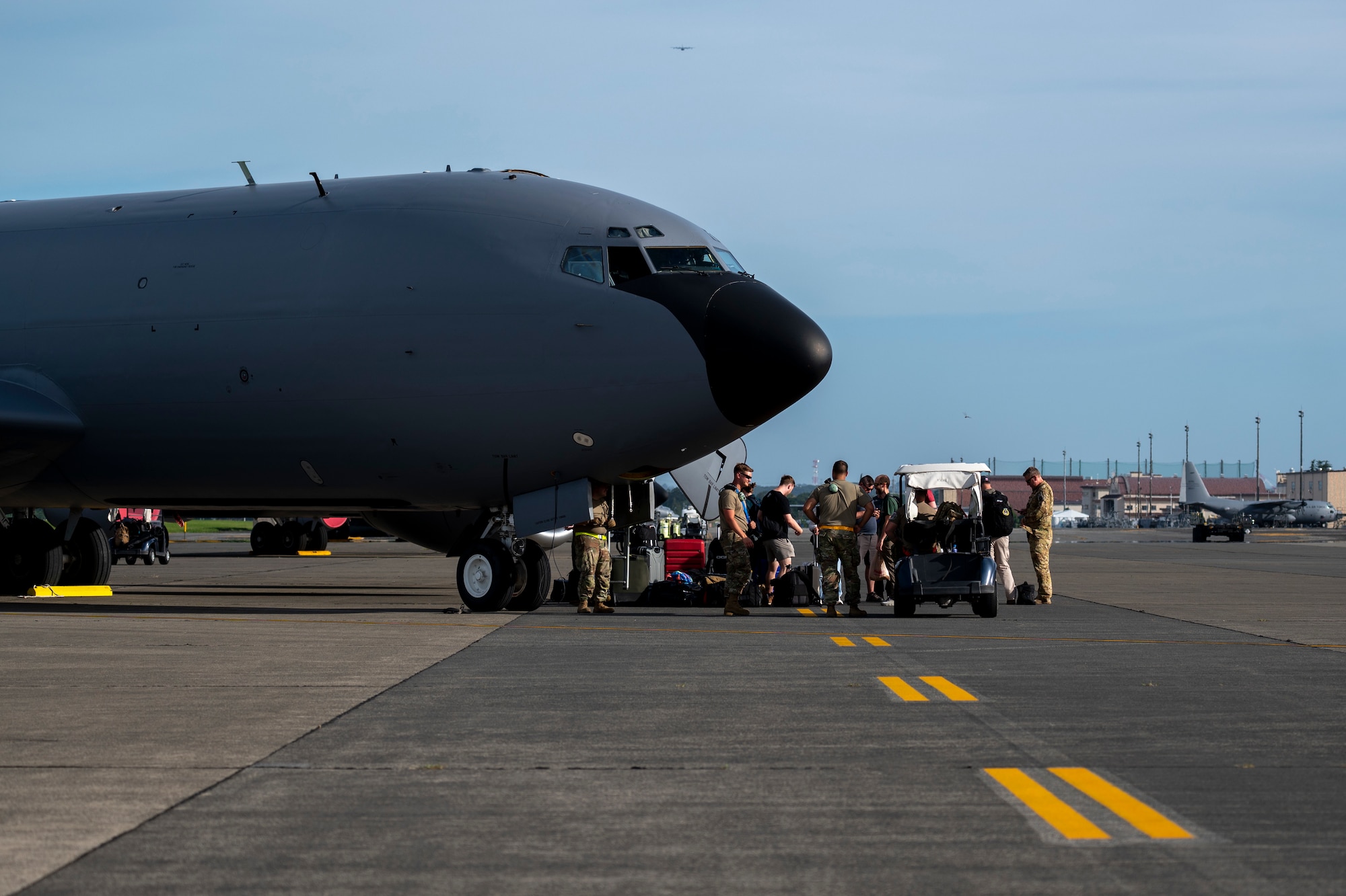 Military members stand in front of a KC-135 Stratotanker.