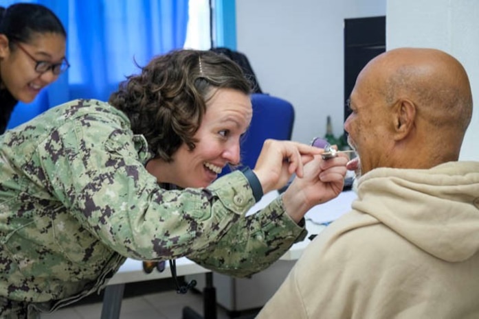 NUKU’ALOFA, Tonga (June 24, 2025) U.S. Navy Cmdr. Samantha Jennings, center, Family Nurse Practitioner deployed in support of Pacific Partnership 2025 (PP-25), examines a local patient during a health consultation at Mu’a Health Centre as part of PP-25 in Nuku’Alofa, Tonga, June 24, 2025. Now in its 21st iteration, the Pacific Partnership series is the largest annual multinational humanitarian assistance and disaster management preparedness mission conducted in the Indo-Pacific. Pacific Partnership works collaboratively with host and partner nations to enhance regional interoperability and disaster response capabilities, increase security and stability in the region, and foster new and enduring friendships in the Indo-Pacific. (U.S. Navy photo by Courtesy Asset/Released)