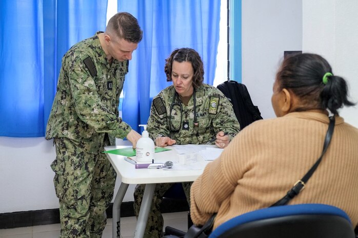 NUKU’ALOFA, Tonga (June 24, 2025) U.S. Navy Cmdr. Samantha Jennings, center, Family Nurse Practitioner deployed in support of Pacific Partnership 2025 (PP-25), and Lt. Louis Pingotti, left, Country Lead for all Medical Lines of Effort in PP-25 Tonga mission stop, assist a local patient during a health consultation at Mu’a Health Centre as part of PP-25 in Nuku’Alofa, Tonga, June 24, 2025. Now in its 21st iteration, the Pacific Partnership series is the largest annual multinational humanitarian assistance and disaster management preparedness mission conducted in the Indo-Pacific. Pacific Partnership works collaboratively with host and partner nations to enhance regional interoperability and disaster response capabilities, increase security and stability in the region, and foster new and enduring friendships in the Indo-Pacific. (U.S. Navy photo by Courtesy Asset/Released)