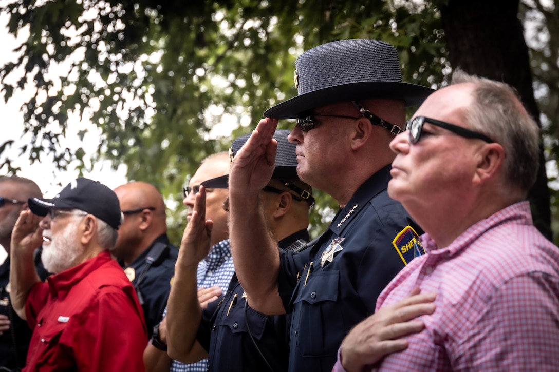 Sheriff Austin Garrett, with Hamilton County Sheriff’s Office salute during the playing of the national anthem at the time of the fallen five memorial ceremony at the Wreath of Honor Fallen Five Memorial Park, Chattanooga, Tennessee, July 16th, 2025. The Wreath of Honor Fallen Five Memorial honors the loss of five U.S. service members tragically killed July 16th, 2015, in a terrorist attack in Chattanooga, today, marking the 10-year anniversary and the vivid memory of their sacrifice. (U.S. Marine Corps photo by Lance Cpl. Edward Spears)