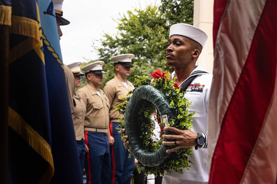 U.S. Navy Hospital Corpsman 1st Class Jordan Dotson, a senior medical department representative with Battery M, 3rd battalion, 14th Marines, 4th Marine Division, Marine Forces Reserve, holds a wreath during the fallen five memorial ceremony at the Wreath of Honor Fallen Five Memorial Park, Chattanooga, Tennessee, July 16th, 2025. The Wreath of Honor Fallen Five Memorial honors the loss of five U.S. service members tragically killed July 16th, 2015, in a terrorist attack in Chattanooga, today, marking the 10-year anniversary and the vivid memory of their sacrifice. (U.S. Marine Corps photo by Lance Cpl. Edward Spears)