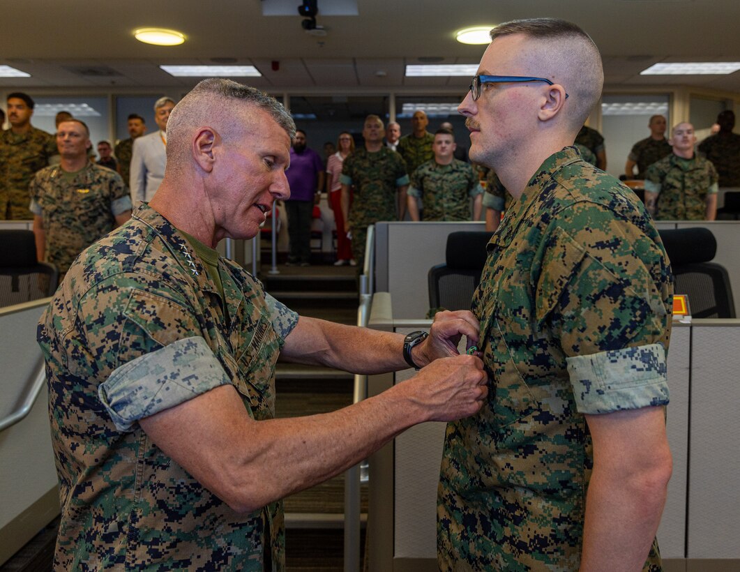 The 39th Commandant of the Marine Corps, Gen. Eric Smith, awards Sgt. Derek McCutchon, command center and mobilization watch staff non-commissioned officer with Headquarters Battalion, Marine Forces Reserve, the Navy Achievement Medal at the Marine Corps Support Facility New Orleans, July 17, 2025. Smith visited New Orleans to oversee and recognize the Marines and staff who dedicate their time and efforts to support the MARFORRES and MARFORSOUTH missions. (U.S. Marine Corps photo by Cpl. Aaron