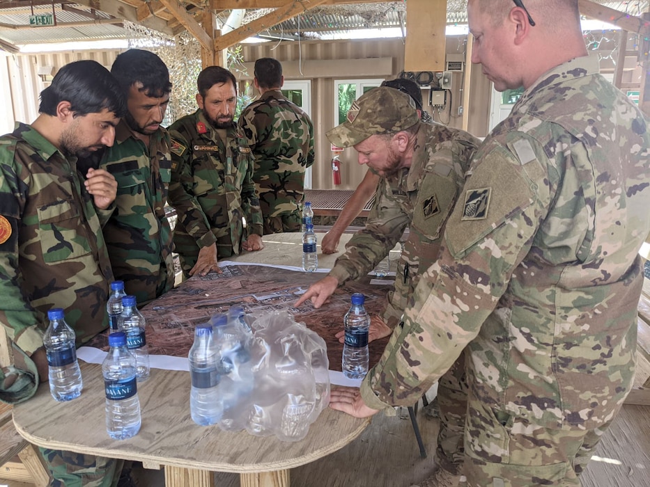 Afghan National Army soldiers speak through an interpreter with U.S. Army Corps of Engineers civilian contracting officer technical representative, Ryan Williams, who explains the operation of the power plant and electrical grid at Forward Operating Base Dwyer in Helmand province, Afghanistan, in late May 2021. The two-day training, conducted under U.S. Army supervision, came during the final weeks before the base’s closure as part of the U.S. withdrawal. (U.S. Army Photo by Ryan Williams)