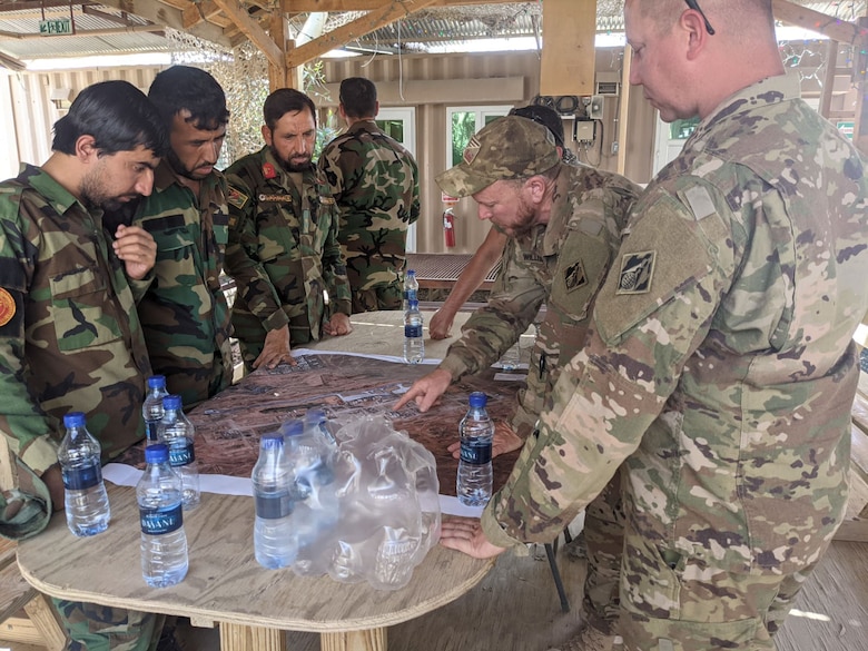 Afghan National Army soldiers speak through an interpreter with U.S. Army Corps of Engineers civilian contracting officer technical representative, Ryan Williams, who explains the operation of the power plant and electrical grid at Forward Operating Base Dwyer in Helmand province, Afghanistan, in late May 2021. The two-day training, conducted under U.S. Army supervision, came during the final weeks before the base’s closure as part of the U.S. withdrawal. (U.S. Army Photo by Ryan Williams)