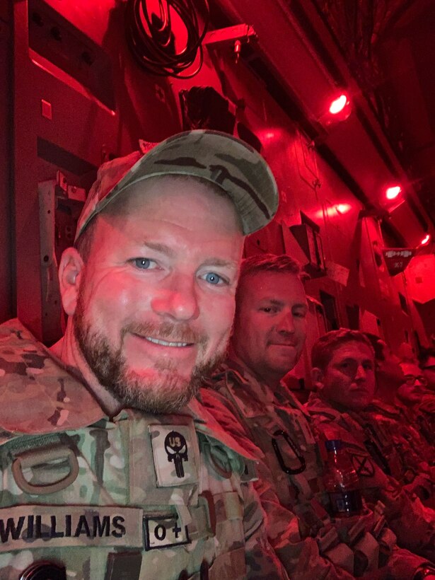 Ryan Williams, a civilian contracting officer technical representative with the U.S. Army Corps of Engineers, sits alongside U.S. Army soldiers in the cargo hold of the final departing aircraft from Forward Operating Base Dwyer in Helmand province, Afghanistan, in late June 2021. The flight, carrying the last 50 personnel, departed under the cover of darkness for Kuwait as part of the base's closure and the broader U.S. withdrawal. (U.S. Army Photo by Ryan Williams)