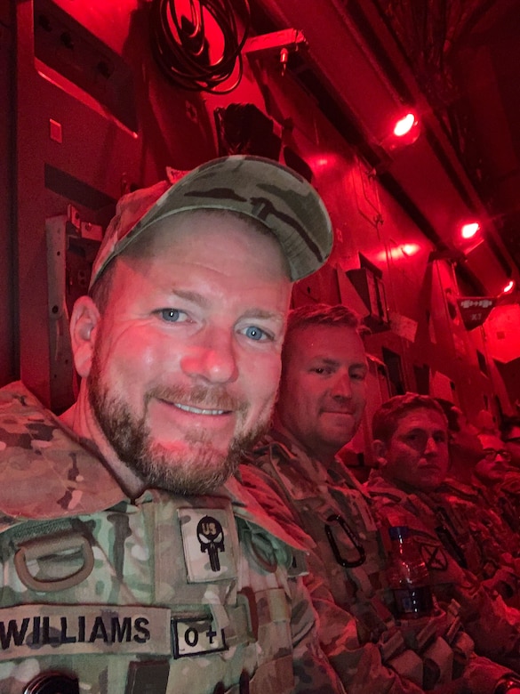 Ryan Williams, a civilian contracting officer technical representative with the U.S. Army Corps of Engineers, sits alongside U.S. Army soldiers in the cargo hold of the final departing aircraft from Forward Operating Base Dwyer in Helmand province, Afghanistan, in late June 2021. The flight, carrying the last 50 personnel, departed under the cover of darkness for Kuwait as part of the base's closure and the broader U.S. withdrawal. (U.S. Army Photo by Ryan Williams)
