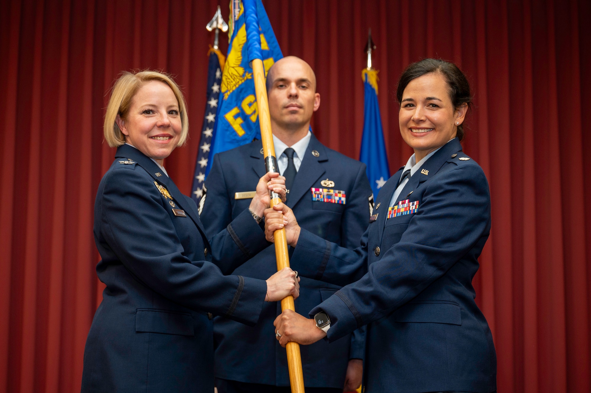377th Mission Support Group commander passes a flag to incoming 377th Force Support Squadron commander.