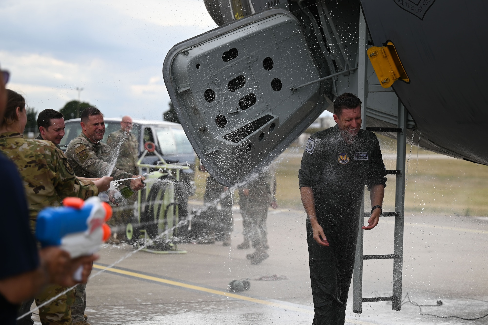 U.S. Airmen assigned to the 100th Air Refueling Wing douse Col. Ryan Garlow, 100th ARW commander, after his fini-flight at RAF Mildenhall, England, July 16, 2025.