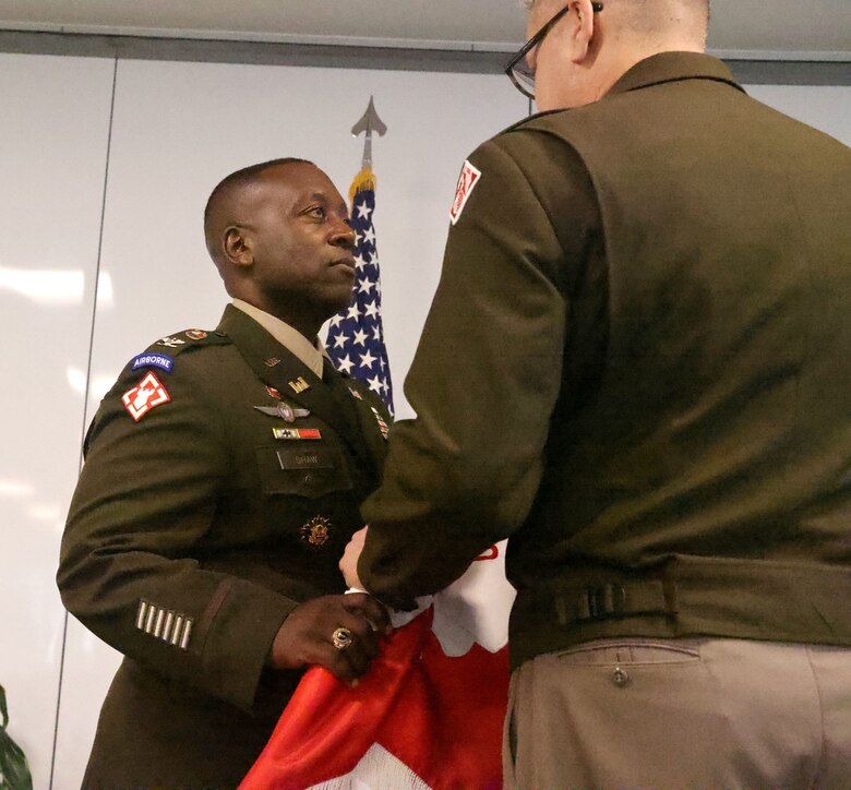 Man handing another man the flag.