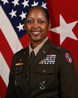 Official portrait of Brigadier General Antoinette Gant in Army green service uniform with US flag and one-star general flag (red field with white star) in background.
