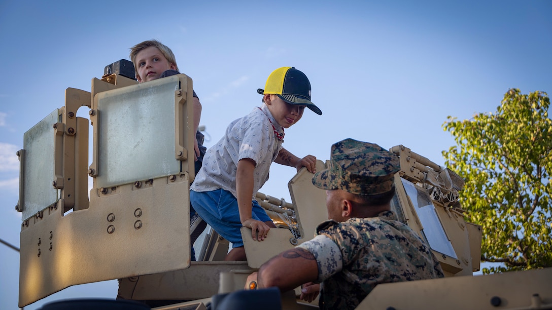 A U.S. Marine with I Marine Expeditionary Force Support Battalion, I MEF Information Group interacts with locals during the Fallbrook Summer Nights community relations event. (U.S. Marine Corps photo by Lance Cpl. Fabian Ortiz)
