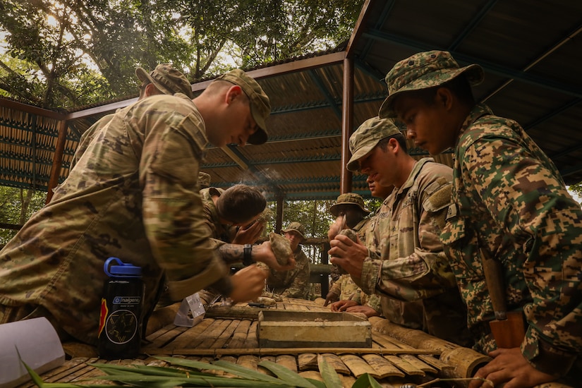 Malaysian Army soldiers demonstrate how to start a fire using natural materials found in the jungle, an essential survival skill shared with their Australian and U.S. Army partners during field training July 20, 2025.